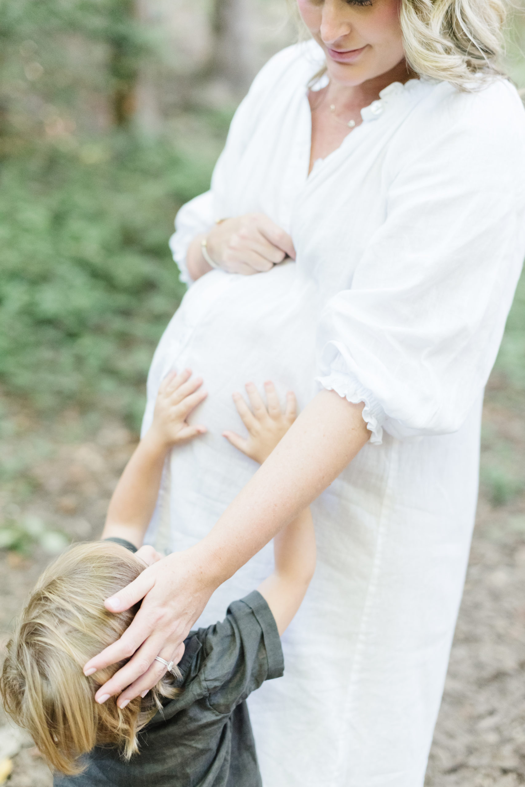 a toddler gently touches his mom's belly during a Northern Virginia maternity session