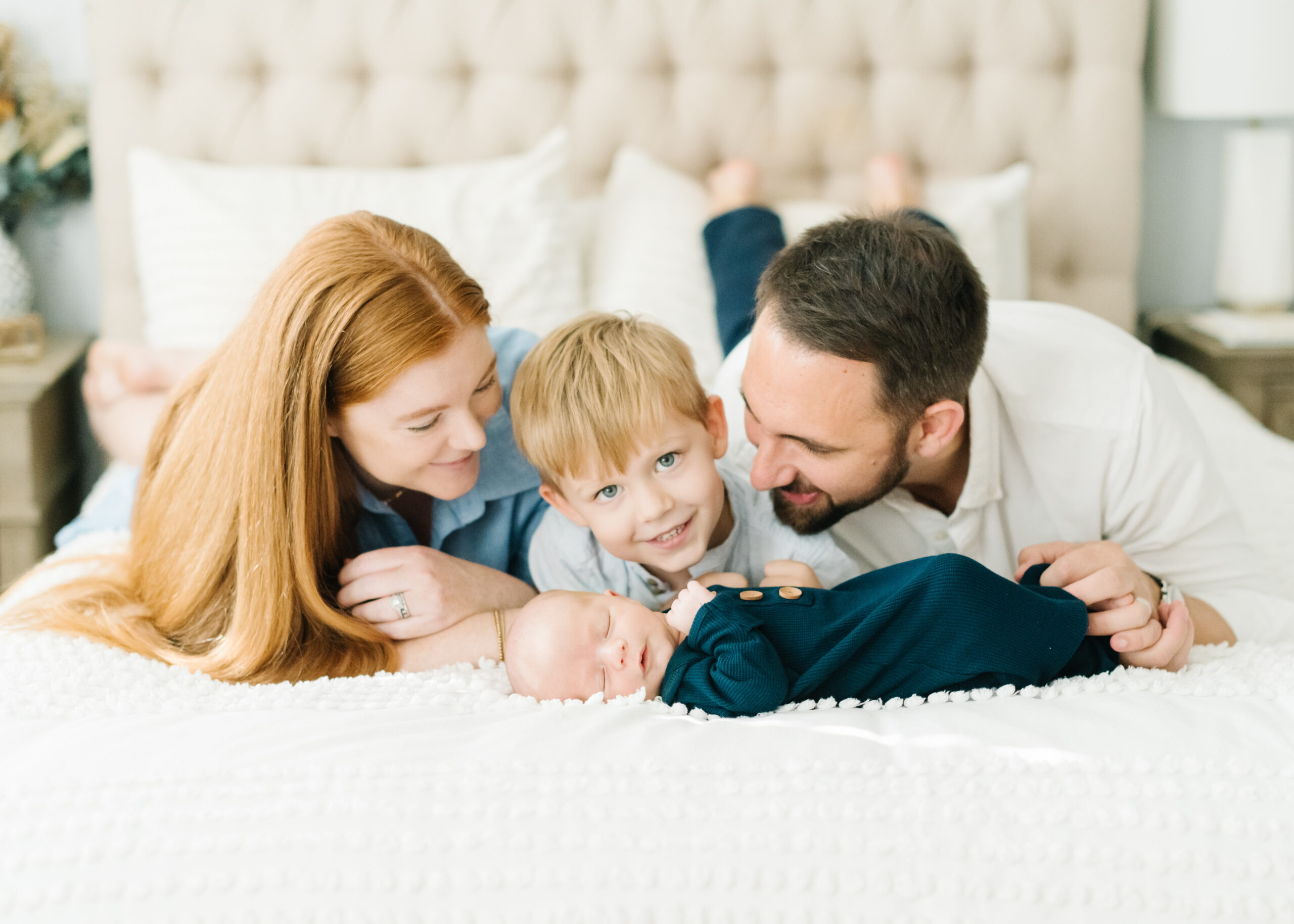 Family on bed at Washington DC newborn lifestyle portrait session