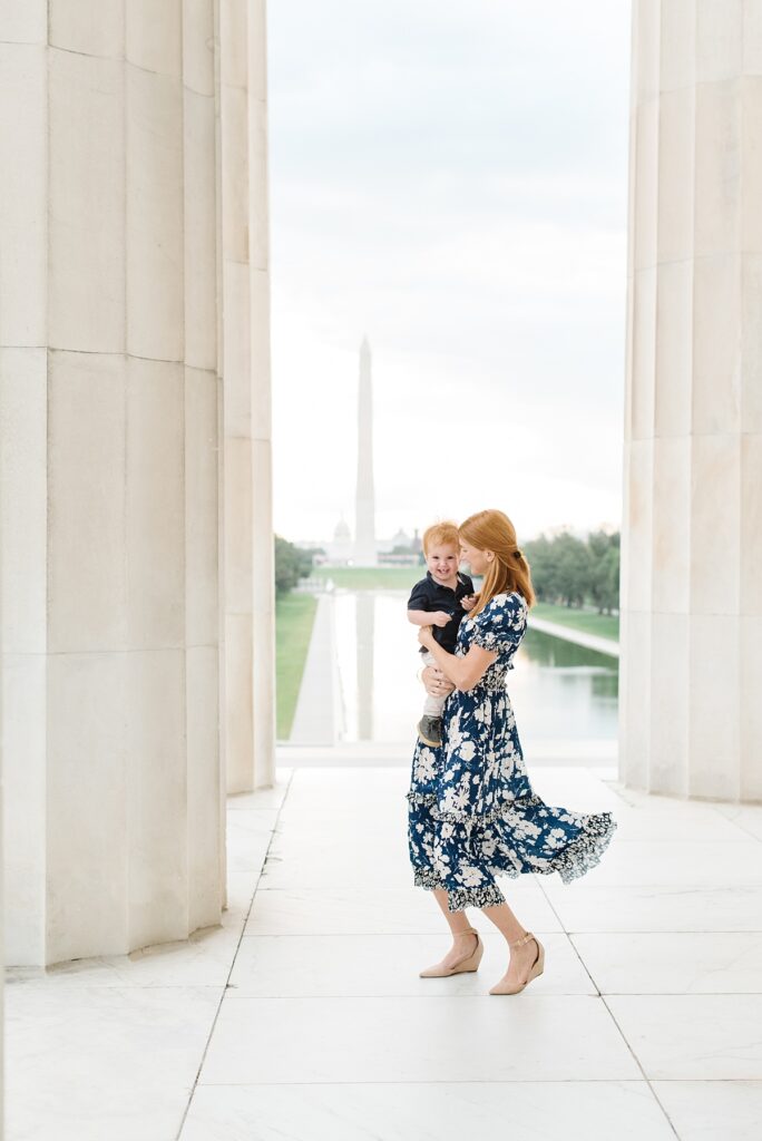 A mom and her son dance around amongst the columns of the Lincoln Memorial at the National Mall during their family portrait session with Washington, DC family photographer Mary Catherine Photography