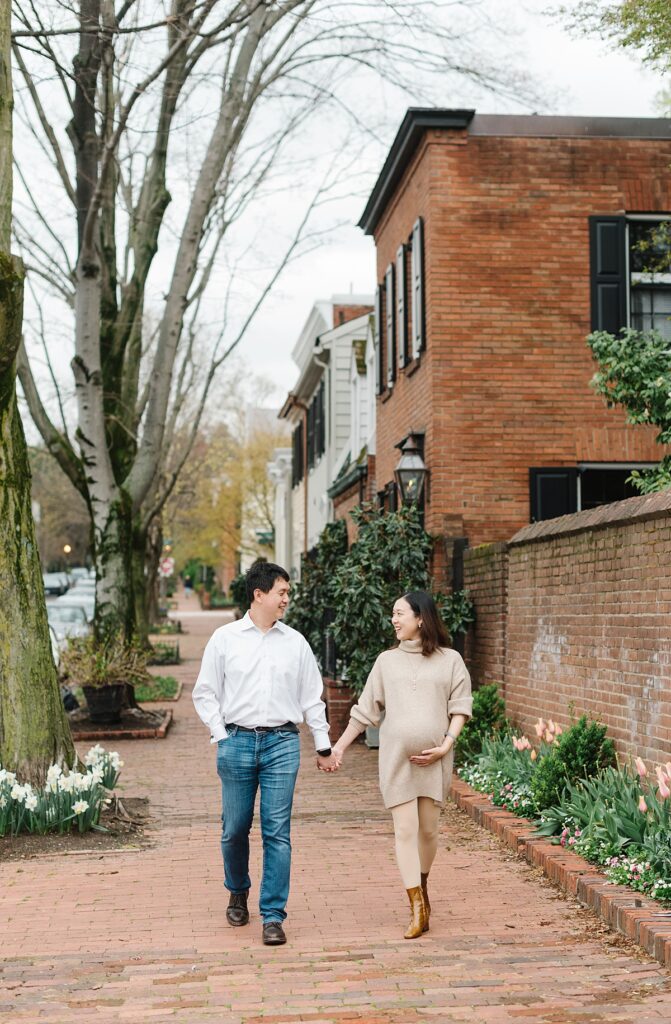 A couple walks hand-in-hand through historic Georgetown during their maternity portrait session with Washington, DC maternity photographer Mary Catherine Photography